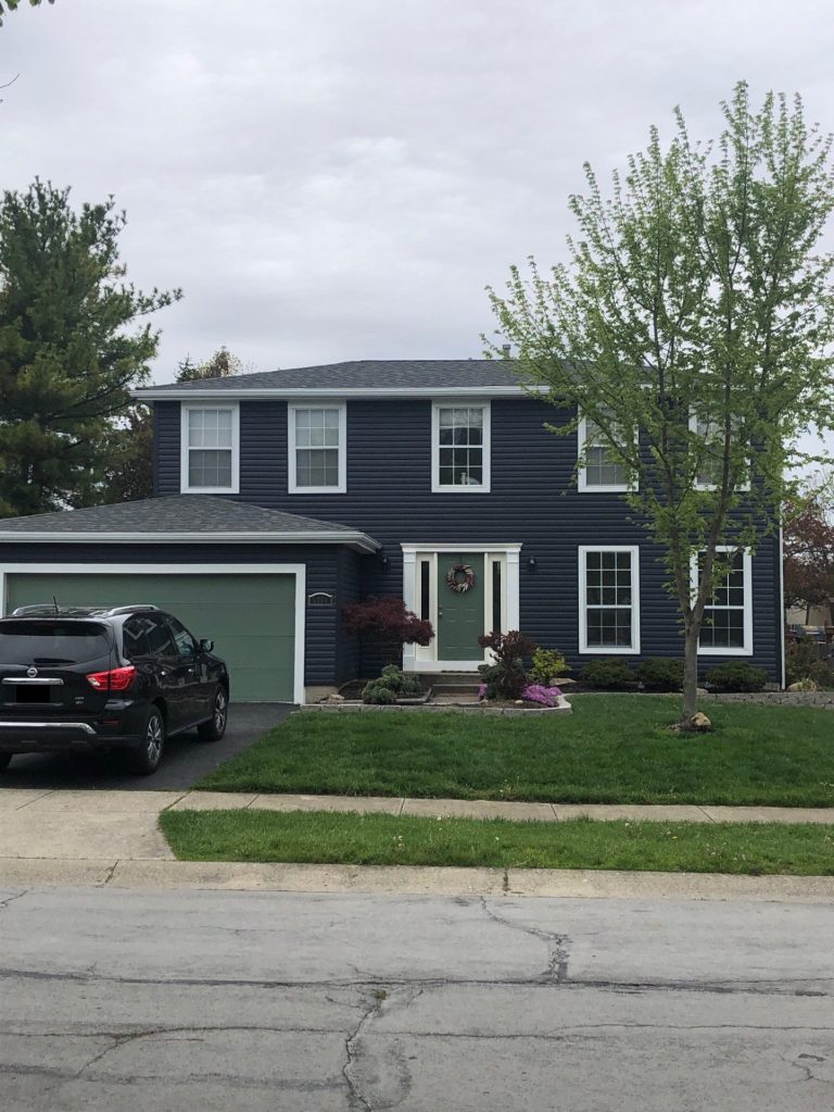 Blue house with new siding, green windows, and doors
